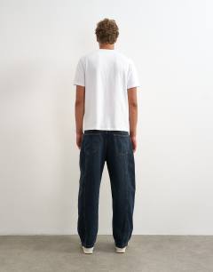 Model wearing Rigid barrel fit panelled jean in clean dark wash