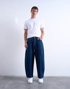 Model wearing Rigid barrel jean in dark wash