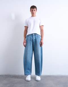 Model wearing Rigid barrel jean in mid wash