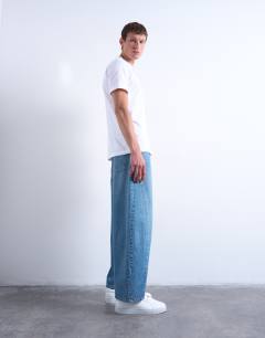 Model wearing Rigid barrel jean in mid wash