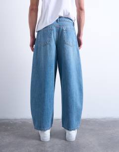Model wearing Rigid barrel jean in mid wash