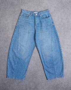 Model wearing Rigid barrel jean in mid wash