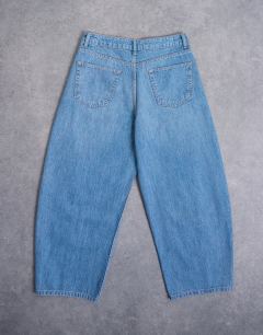 Model wearing Rigid barrel jean in mid wash