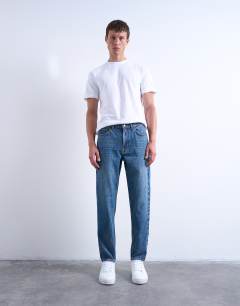 Model wearing Rigid taper jean in mid wash