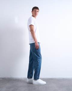 Model wearing Rigid taper jean in mid wash