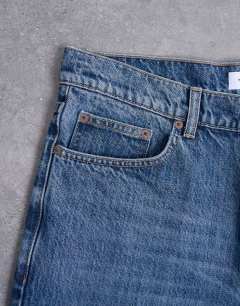 Model wearing Rigid taper jean in mid wash