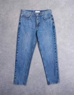 Model wearing Rigid taper jean in mid wash
