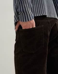 Model wearing Straight fit jeans with coated velour finish in brown