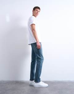 Model wearing Stretch slim jean in mid wash
