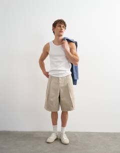 Model wearing Twill bermuda short with pronounced pleat in stone