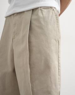 Model wearing Twill bermuda short with pronounced pleat in stone