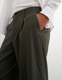 Model wearing Wide leg pinstripe trousers in dark green