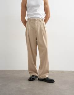 Model wearing Wide leg pleated trouser in stone