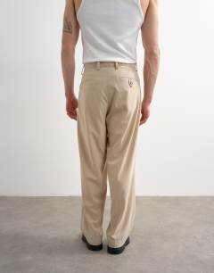 Model wearing Wide leg pleated trouser in stone