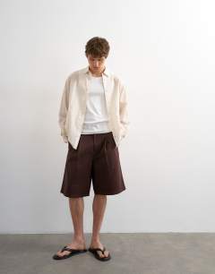 Model wearing Wide leg twill bermuda short with pleats in brown