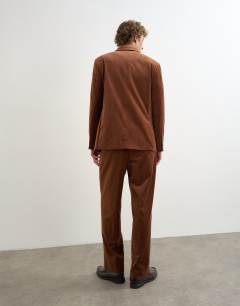 Model wearing Wide leg velour stripe trousers with pleats in tan