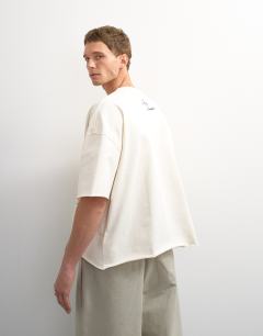 Model wearing Topman x Akilah boxy fit crop abstract scenic graphic t-shirt with embroidery in ecru