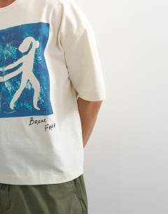 Model wearing X Jing boxy fit crop abstract breaking free graphic t-shirt with embroidery in ecru