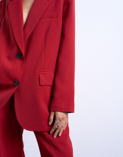 Model wearing 2 button relaxed fit blazer in cherry red