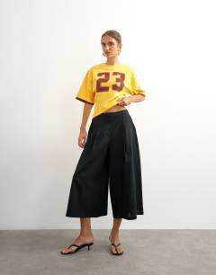 Model wearing Topshop '23' graphic shrunken tee in orange