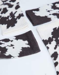 Model wearing 2pk sporty rib cow print socks in choc and cream cow