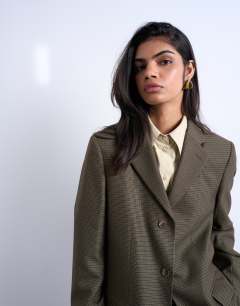 Model wearing 3 button mensy blazer in heritage check in green