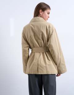 Model wearing 4 pocket cotton shacket with quilted lining in beige