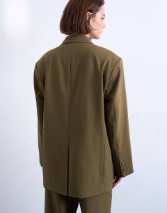 Model wearing 6 button double breasted tuxedo blazer in khaki