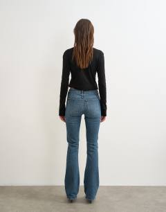 Model wearing 90's bootcut low rise jean in deep blue 