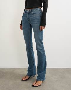 Model wearing 90's bootcut low rise jean in deep blue 