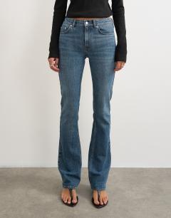 Model wearing 90's bootcut low rise jean in deep blue 