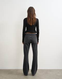 Model wearing 90's bootcut low rise jean in washed black