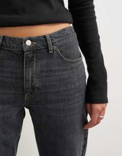 Model wearing 90's bootcut low rise jean in washed black