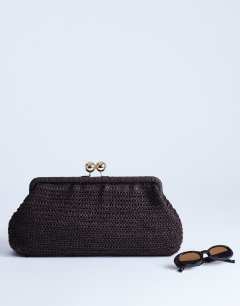 Model wearing Abbie woven clutch bag in chocolate