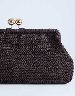 Model wearing Abbie woven clutch bag in chocolate
