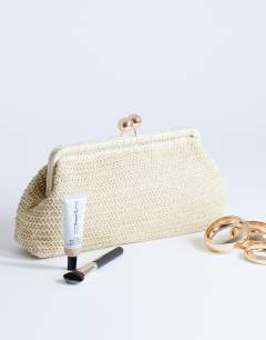 Model wearing Abbie woven clutch bag in natural