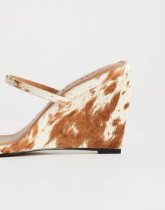 Model wearing Abi strappy wedge heel in cow print hair on real leather