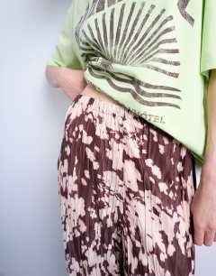 Model wearing Abstract animal print plisse trousers in brown