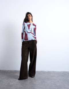 Model wearing Abstract print long sleeve top in blue and burgundy