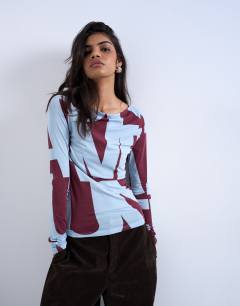 Model wearing Abstract print long sleeve top in blue and burgundy