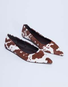 Model wearing Ace point toe flat shoe in cow print hair on real leather 