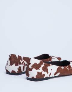 Model wearing Ace point toe flat shoe in cow print hair on real leather 