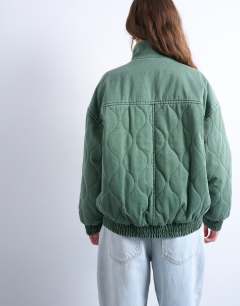 Model wearing Acid wash oversized quilted cotton bomber jacket in green