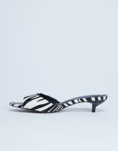 Model wearing Alba peep toe kitten heel mule in zebra print hair on real leather