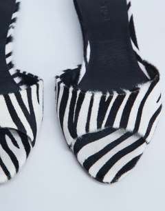 Model wearing Alba peep toe kitten heel mule in zebra print hair on real leather