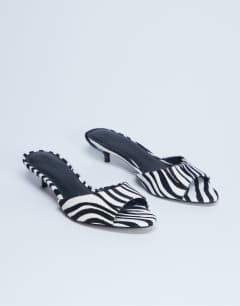 Model wearing Alba real leather peep toe kitten heel mule in zebra pony