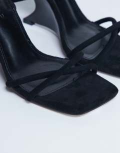 Model wearing Alexa wedge heeled mule in black