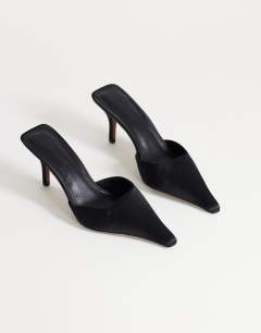 Model wearing Alfie pointed heeled court in black satin