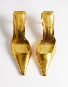 Model wearing Alfie pointed mid heeled court in gold