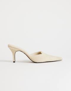 Model wearing Alfie real hair on leather pointed mid heeled mule court shoe in off white